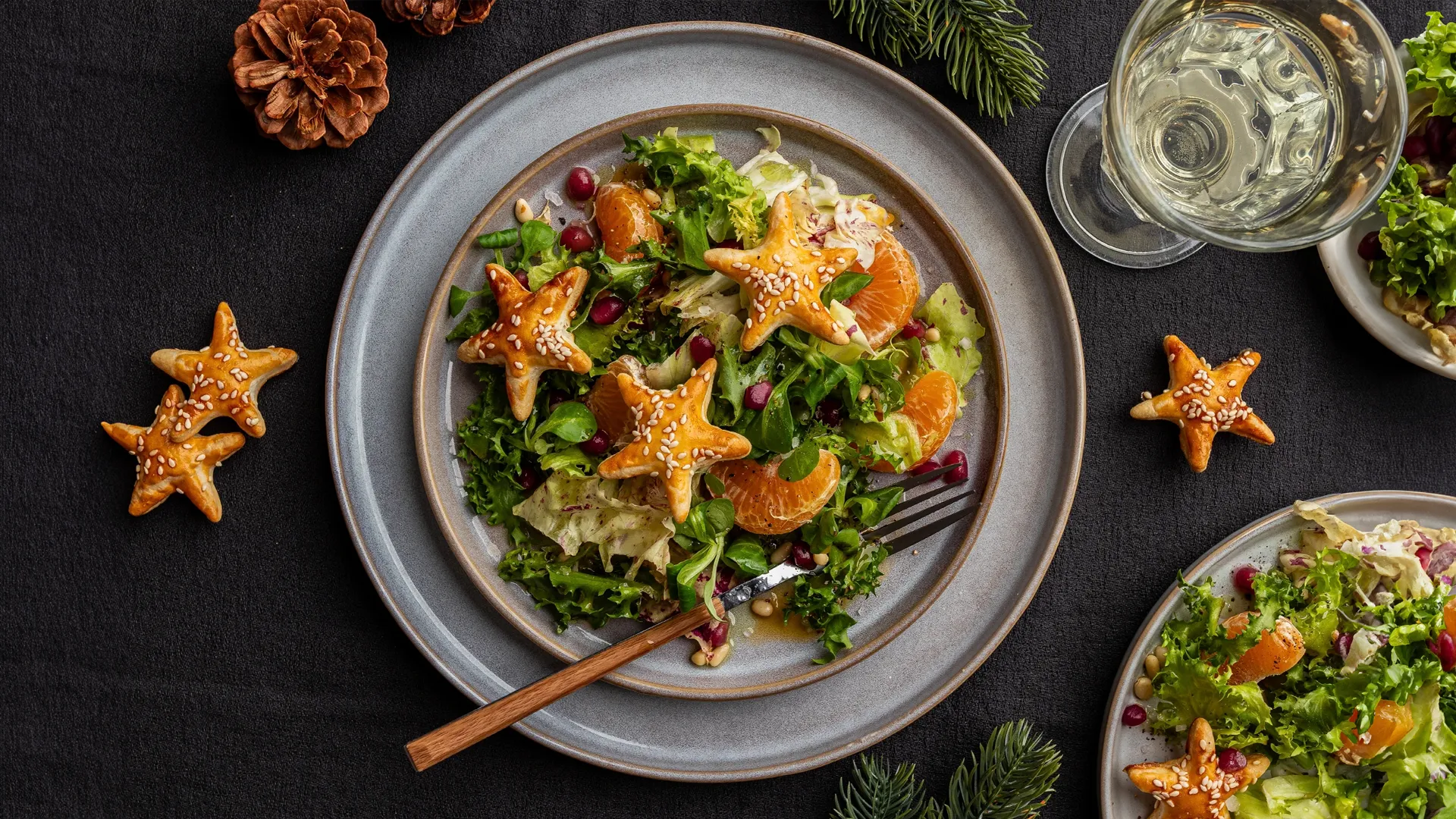 Authentische Food-Fotografie Trends 2025: Ein frischer Wintersalat mit Mandarinen, Granatapfelkernen und sternförmigem Gebäck, inszeniert von Socialfood im natürlichen Look.